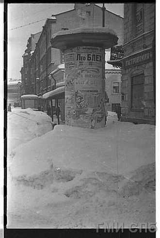 Чертов Г.  &nbsp;&nbsp;&nbsp; На улице Правды. Афишная тумба, занесённая снегом. Зима 1942 года